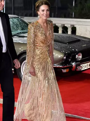 Kate Middleton wearing a gold embellished cape dress and oversized earrings