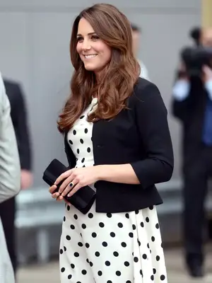 Kate Middleton wearing a black and white polka dot dress with a black jacket and a black clutch