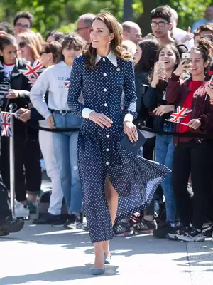 Kate Middleton wearing a blue and white polka dot dress and minimal jewelry