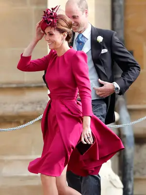 Kate Middleton wearing a fuchsia knee-length dress with a matching fascinator 