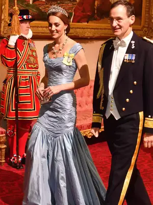 Kate Middleton wearing a blue gown with a pearl necklace and crown