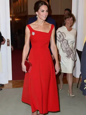 Kate Middleton wearing a red dress with a maple leaf flag brooch 