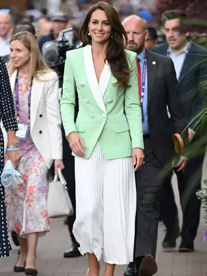 Kate Middleton wearing a green blazer with a white pleated skirt 