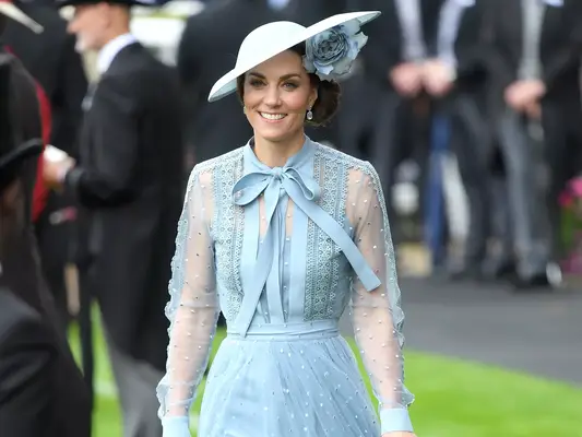 Kate Middleton wearing a light blue dress with sheer sleeves and a matching hat with flower detailing