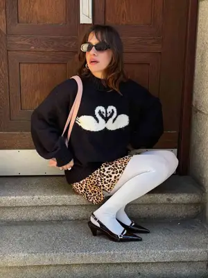 Model wearing a swan sweater, cheetah skirt, and white tights