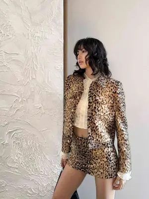 Lisa posing for a photo while wearing a leopard print coat and mini skirt