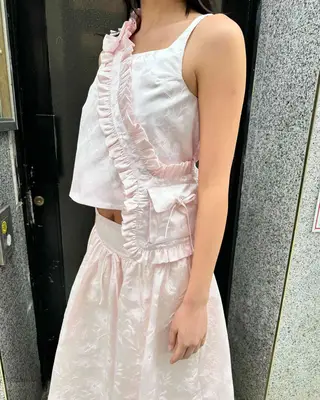 model wearing white dress with a sash detail