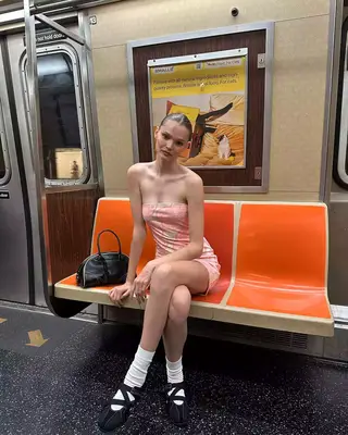 Model wearing a dress and sporty ballet flats on the train