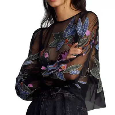 By Anthropologie Long-Sleeve Applique Mesh Top in black with floral and leaf designs on model paired with black denim