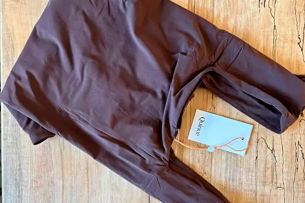 The Quince Second Skin Square Neck Long Sleeve Bodysuit folded with the tags on