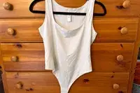 The lululemon Wundermost Ultra-Soft Nulu Square-Neck Sleeveless Bodysuit hangs from a hanger