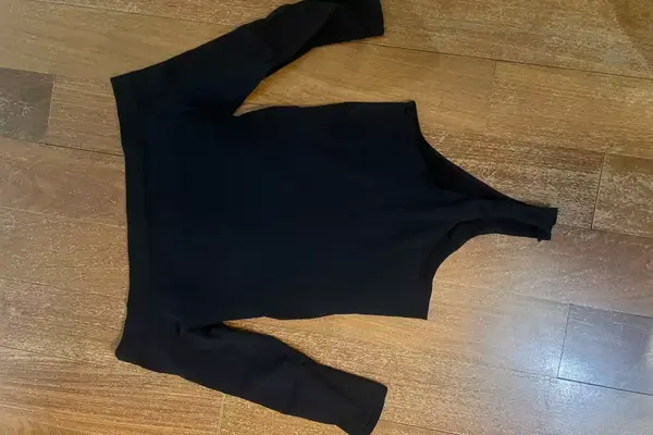 The Commando Ballet Off-Shoulder Bodysuit on a wooden floor