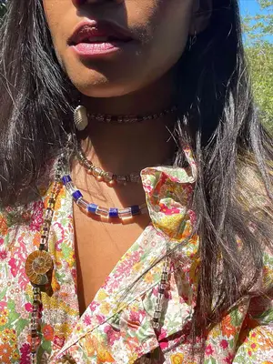 Close-up of woman wearing layered beaded necklaces and colorful blouse