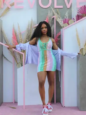 SZA wearing a pastel stripe knit dress, pink Converse, and pastel lavender blouse