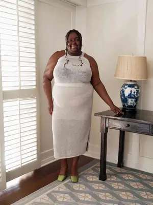 Abisola Omole wearing a crochet knit set in cream and green satin mule shoes. 