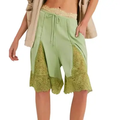 model wearing green shorts with lace cutouts