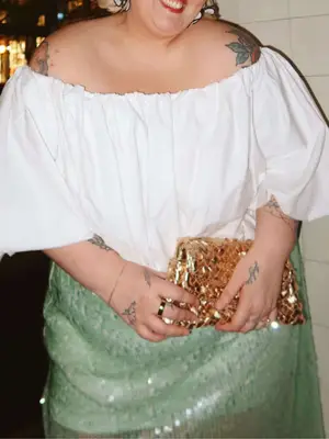 Abby Bible wearing a white top and green sequin skirt