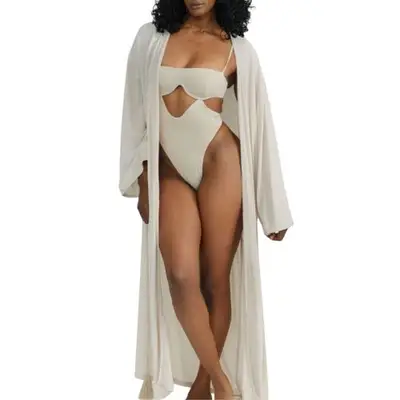 model wearing a swimsuit and beige cover-up