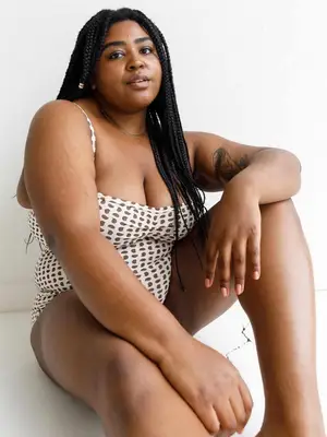 Person wearing brown and white swimsuit and braided hairstyle