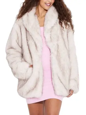 model wearing a beige, oversized faux fur coat and pink dress