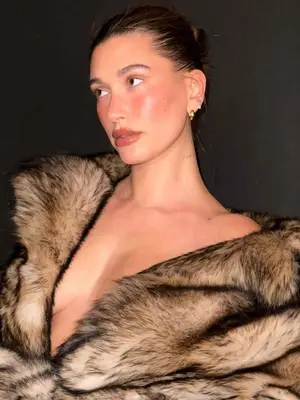 Hailey Bieber wearing gold earrings and a large fur coat