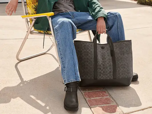 brown and black coach tote on ground
