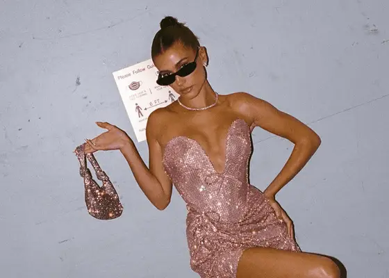 hailey bieber with pink sparkly handbag