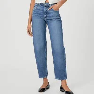 model wearing slim blue denim barrel jeans with black ballet flats