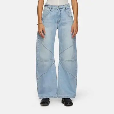 model wearing blue denim wide barrel jeans with black boots