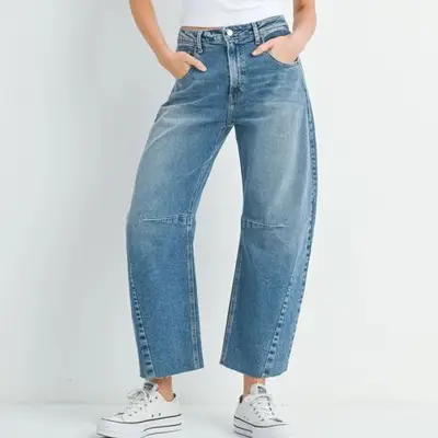 model wearing blue denim barrel jeans with white converse sneakers