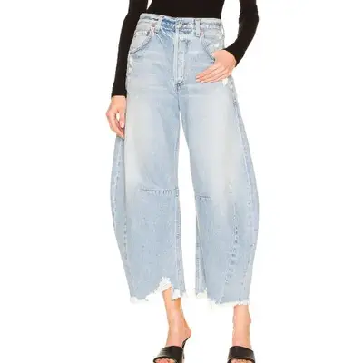 model wearing light wash blue denim cropped barrel jeans