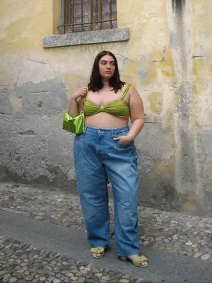 Nadia Aboulhosn wears a green bikini top with matching bag, relaxed jeans, and green bow heeled sandals