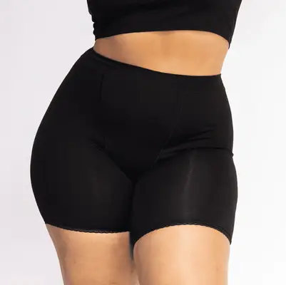 MYM Beauty editor Bella Cacciatore wears a white fitted long-sleeve top, pleated midi skirt, and black boots