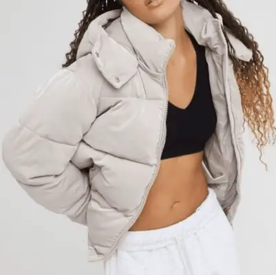 MYM Beauty editor Jasmine Phillips sits on a couch wearing a black feathered pajama set