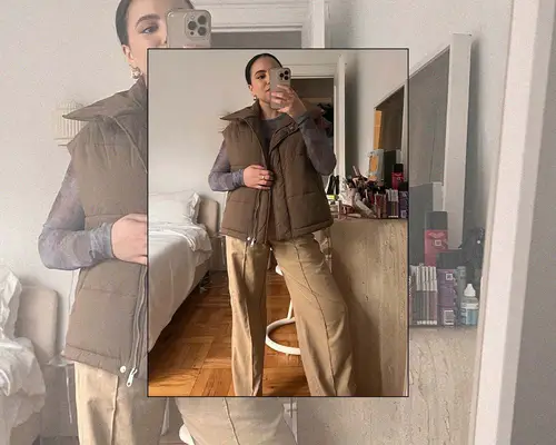MYM Beauty editor Star Donaldson wears a brown puffer vest, wide leg tan pants, and a long sleeve gray top