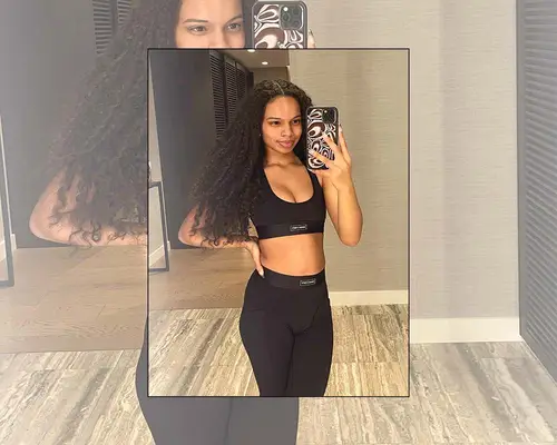 MYM Beauty editor Olivia Hancock takes a mirror selfie in a black workout bra top and leggings