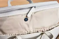 A close up of the zipper on the calpak haven laptop tote bag