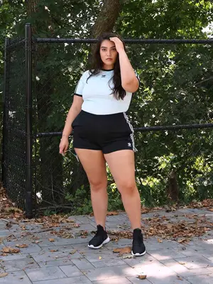 Nadia Aboulhosn wears a black and white Adidas t-shirt and shorts set with stripes, paired with black and white sneakers