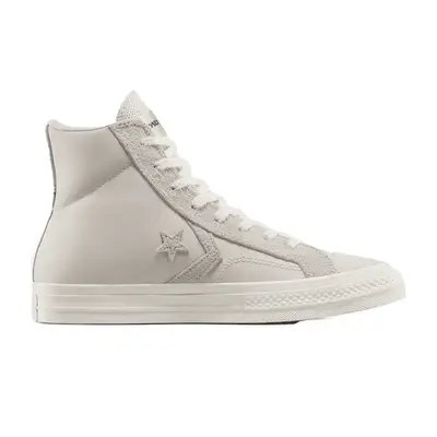 Close-up of woman wearing red top, wide leg jeans, cream flats, and black blazer