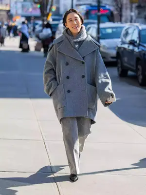 Eva Chen wears a gray monochromatic outfit comprising a sweater, jeans, and coat