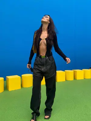 Bella Hadid wears dark slouchy jeans and black bodysuit with cutout