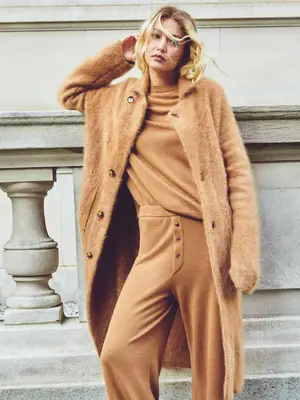 Gigi Hadid wears a camel-colored knit matching set and oversized textured cardigan