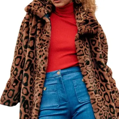 Sezane Lenzo Coat in brown leopard on model styled with red sweater and jeans
