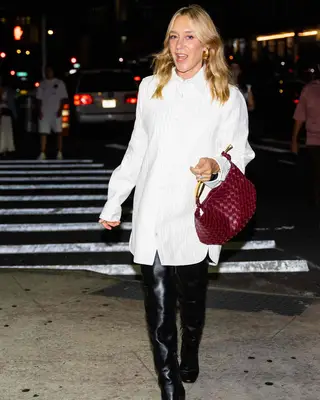 Chloe Sevigny wearing a white oversized button-down with black thigh-high boots