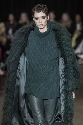 Model wearing fluffy coat and cable knit sweater on the Sergio Hudson fall 2025 runway