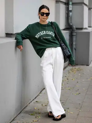 Model wearing a white cropped racerback tank top 