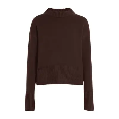 Matilda Djerf wears a chocolate brown blazer, striped button-down shirt, and updo hairstyle