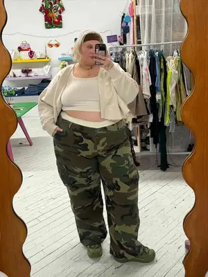 Abby Bible wears a white tank, cardigan, and camo pants