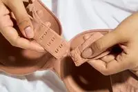 Hands hold the hooks on a Victoriaâs Secret Push-Up Perfect Shape Bra