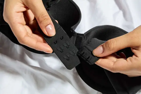 Hands hold the hooks on a Skims Fits Everybody Push-Up Bra
